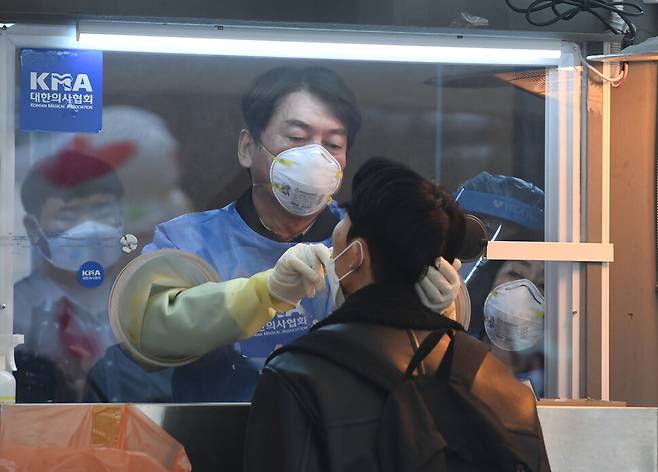 안철수 국민의당 대표가 15일 서울광장에 마련된 임시 선별검사소에서 의료 자원봉사에 나서 검체를 채취하고 있다. 국회사진기자단