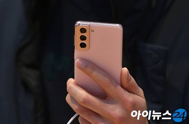 삼성전자가 15일(한국시간) 자정 온라인에서 진행된 '삼성 갤럭시 언팩 2021'을 통해 공개한 플래그십 스마트폰 갤럭시 S21 시리즈를 공개했다. 이날 서울 서초구 삼성전자 서초사옥 딜라이트샵을 찾은 시민들이 새로운 갤럭시 S21을 살펴보고 있다.