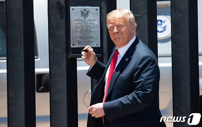 도널드 트럼프 미국 대통령이 애리조나주 산루이에서 200마일 규모의 멕시코 국경장벽 완공 기념식에 참석해 명판에 사인을 하고 있다. © AFP=뉴스1