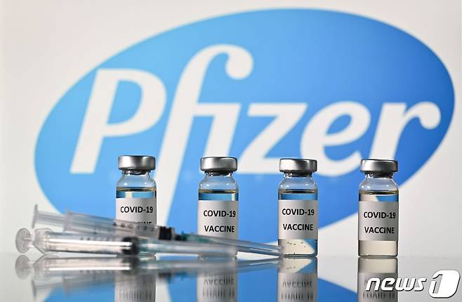 코로나19 백신 스티커가 부착된 병과 미국 제약회사 화이저 로고가 부착된 주사기. © AFP=뉴스1