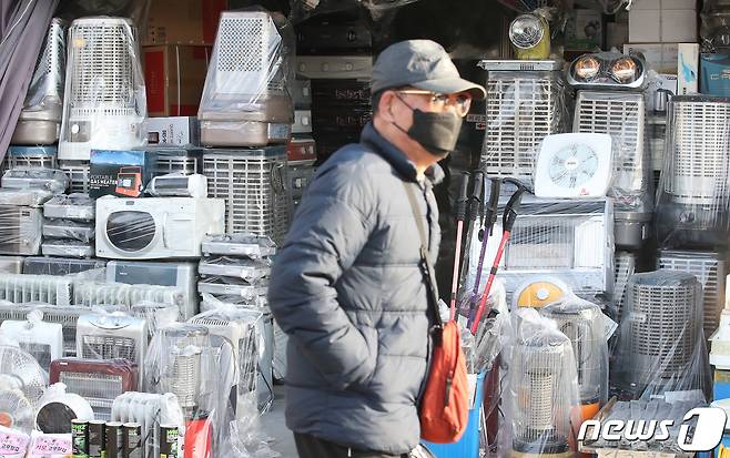 17일 오후 서울 중구 황학동 중앙시장을 찾은 한 시민이 진열된 난방기기 앞을 지나고 있다. 2021.1.17/뉴스1 © News1 임세영 기자
