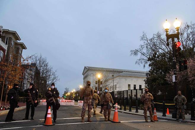 16일(현지시각) 워싱턴DC 미 의회 주변에서 군인과 경찰들이 중무장한채 경계 근무를 하고 있다. /AFP 연합뉴스