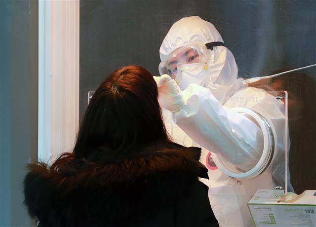 ‘검체 채취’ - 14일 오전 서울역 광장에 마련된 신종 코로나바이러스 감염증(코로나19) 임시선별진료소에서 의료진이 피검사자의 검체를 채취하고 있다. 2021.1.14 뉴스1