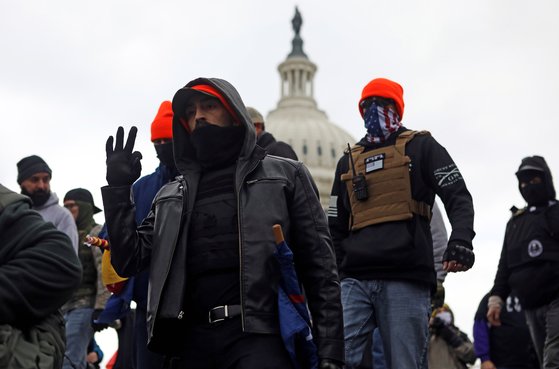 6일(현지시간) 미국 워싱턴 의사당 앞으로 몰려간 극우 무장단체 프라우드 보이즈의 일원으로 보이는 남성이 손으로 ‘백인의 힘’을 뜻하는 ‘OK’ 사인을 해 보이고 있다. [로이터=연합뉴스]