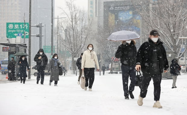 눈이 내리는 18일 오전 서울 광화문광장 인근에서 시민들이 눈을 맞으며 걸어가고 있다. /사진=연합뉴스