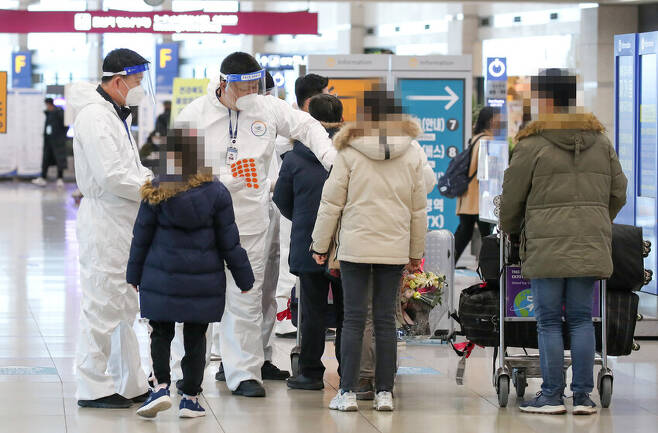 19일 오후 인천국제공항 제1터미널 입국장에서 해외입국자들이 방역관계자에게 안내를 받고 있다. 연합뉴스