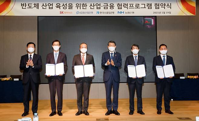 Financial Services Commission Chairman Eun Sung-soo (third from right) and SK hynix CEO Lee Seok-hee (third from left) pose after signing an agreement to provide $3 billion in loans to support the chipmaker‘s M&A deals in Icheon, Gyeonggi Province, Tuesday. (FSC)