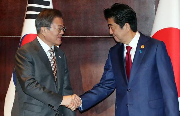 문재인 대통령과 아베 신조 일본 총리가 2019년 12월 24일 중국 청두 샹그릴라 호텔에서 정상회담을 하기 전 악수를 나누고 있다.