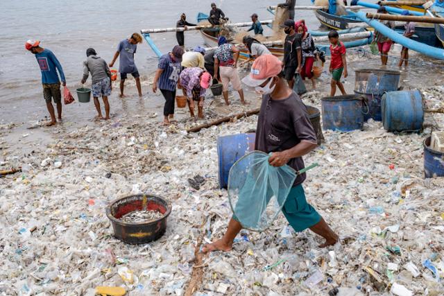 인도네시아 발리섬 끄동아난의 어촌에서 18일 어부들이 플라스틱 쓰레기가 덮인 해변에서 작업을 하고 있다. 발리=EPA 연합뉴스