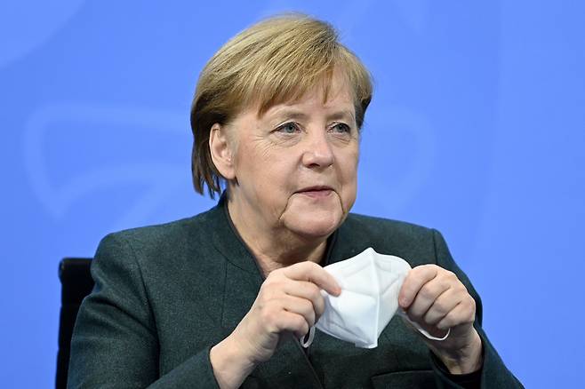 앙겔라 메르켈 독일 총리가 19일(현지시간) 화상 기자회견에서 마스크를 벗으며 봉쇄 조치 연장을 발표하고 있다.[EPA]