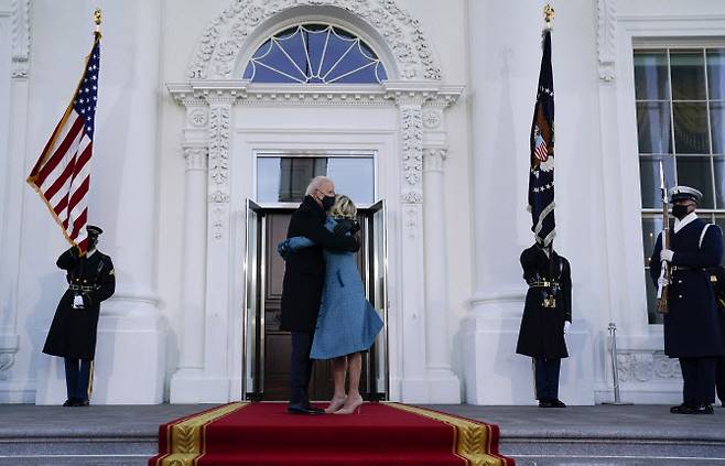 바이든 미국 대통령과 질 바이든 여사가 20일(현지시간) 워싱턴DC 연방 의사당에서 열린 공식 취임식을 마친 후 백악관 북쪽 입구인 ‘노스 포르티코’에 도착한 후 포옹하고 있다. (사진=AP/뉴시스 제공)