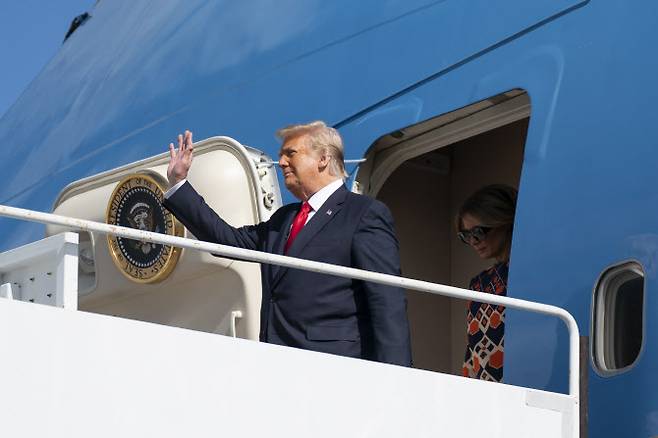 도널드 트럼프 미국 대통령이 20일(현지시간) 플로리다주 팜비치 국제공항에 착륙한 전용기 에어포스원에서 내리며 자신의 지지자들을 향해 손을 흔들고 있다. (사진=AFP)