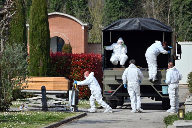 지난해 3월 21일 이탈리아 베르가모에서 코로나19로 숨진 환자들의 시신이 군 트럭으로 북부 페라라 공동묘지에 도착해 운구되고 있다. 관계자는 베르가모 공동묘지의 최대 수용량이 넘어서 페라라까지 시신을 운반해야 했다고 밝혔다. 페라라=AP 뉴시스