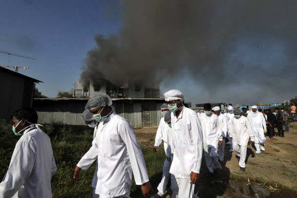 화재가 난 인도 세룸 생산시설에서 근로자들이 빠져나오고 있다. AP 연합뉴스