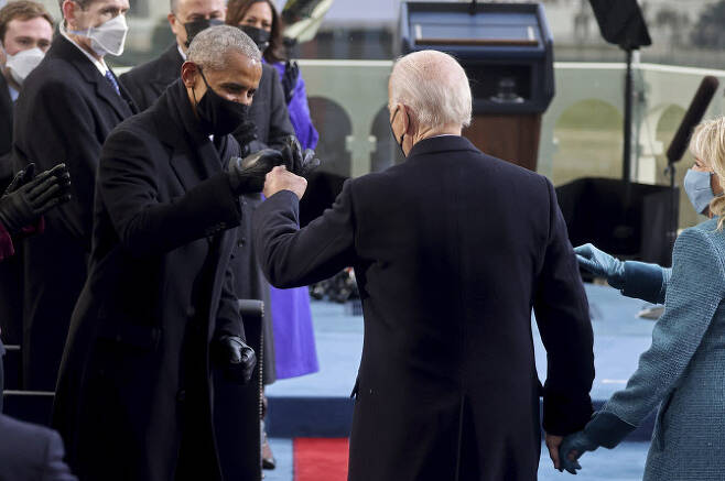 조 바이든 제46대 미국 대통령(오른쪽)이 20일(현지시간) 워싱턴DC 연방 의사당 야외무대에 설치된 취임식장에서 버락 오바마 전 대통령과 손 인사를 하고 있다. (사진=로이터/뉴시스 제공)