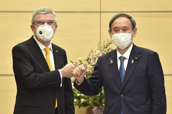 바흐 IOC 위원장과 '주먹 인사' 나누는 스가 일본 총리. /AP·연합뉴스