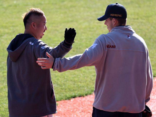 두산 베어스 투수 크리스 플렉센(오른쪽)이 지난해 11월 8일 서울 송파구 잠실구장에서 2020시즌 프로야구 플레이오프 1차전을 앞두고 베테랑 투수 유희관과 대화하고 있다. 연합뉴스