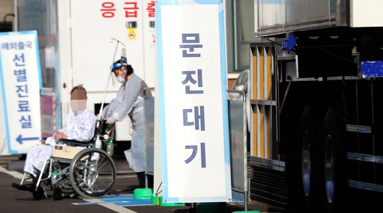 지난 21일 서울 국립중앙의료원 코로나19 선별진료소에서 시민이 검사를 받고 병동으로 이동하고 있다. [연합뉴스]