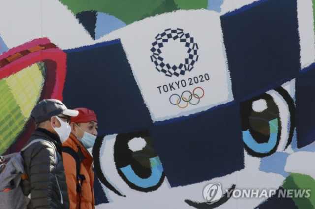 지난 19일 도쿄에서 시민들이 도쿄올림픽·패럴림픽 홍보 포스터 앞을 지나가고 있다./AP 연합뉴스