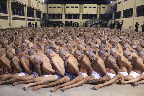 지난해 4월 엘살바도르 수도 산살바도르의 한 교도소에서 속옷차람의 수감자 수백명이 좁은 공간에 포개져 앉아있다. [AP=연합뉴스]