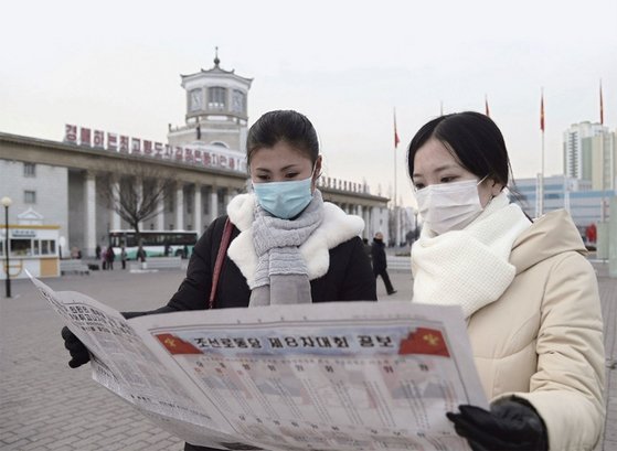 1월 11일 평양역 앞에서 시민들이 조선노동당 8차 대회 소식이 실린 신문을 보고 있다. / 사진:연합뉴스