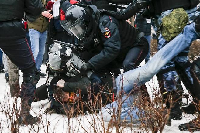 러시아 경찰들이 23일(현지시간) 눈 쌓인 모스크바 푸시긴 광장에서 야당 지도자 알렉세이 나발니의 석방을 촉구하는 시위에 참여한 시위자를 체포하고 있다. 체포되는 시위자의 얼굴은 피투성이이다. 이날 영하 50도의 강추위 속에 러시아 전역 주요 도시들에서 나발니 석방을 촉구하는 시위가 벌어졌으며 3454명의 시위자가 경찰에 체포됐다. 나발니의 아내 율리아도 체포됐다. /AP=뉴시스