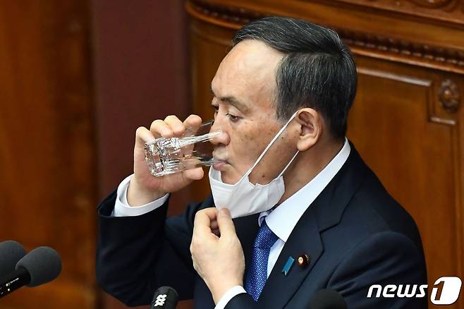 스가 요시히데 일본 총리가 18일(현지시간) 도쿄 정기국회에서 시정방침 연설을 하는 도중 물을 마시고 있다. © AFP=뉴스1 © News1 우동명 기자