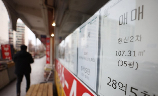 한 시민이 부동산 매물정보가 붙어있는 공인중개업소 앞을 지나가고 있다. <연합뉴스>