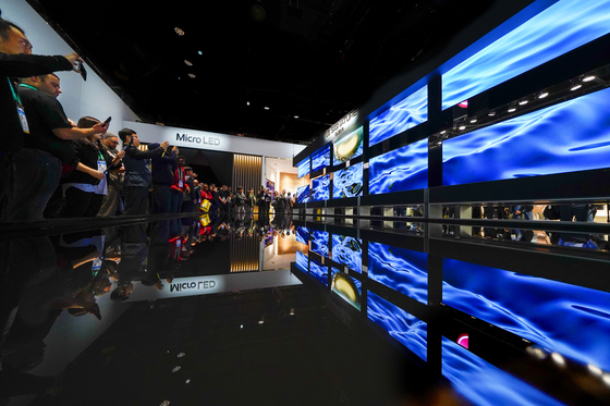 CES attendees flock to see LG Electronics’ rollable OLED TV, during CES 2020 in Las Vegas. [AP]