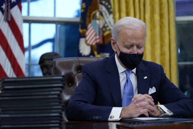 조 바이든 미국 대통령이 대통령 업무를 시작했던 20일(현지시간) 백악관 집무실에서 첫 행정명령에 서명하기에 앞서 눈을 감은 채 생각에 잠겨 있다. AP뉴시스
