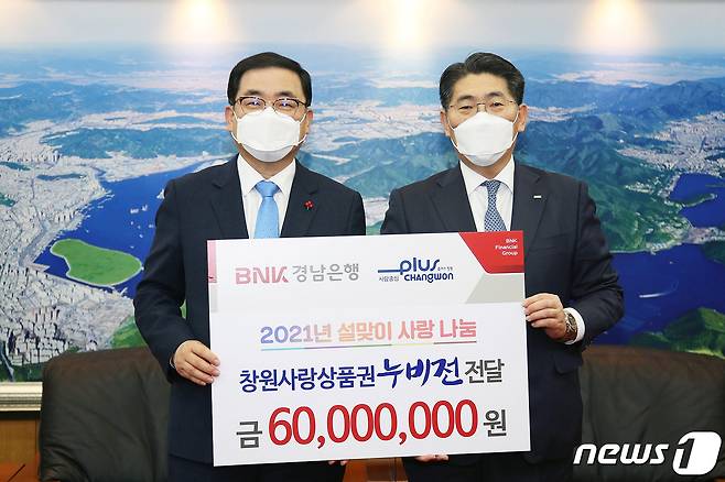 BNK경남은행 김백용 상무(사진 오른쪽)가 창원시 허성무 시장에게 ‘창원사랑상품권 기탁 증서’를 전달하고 있다© 뉴스1