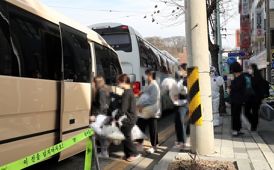 IEM국제학교 코로나19 확진자들이 치료센터로 이동하기 위해 차량에 탑승하고 있다. 연합뉴스