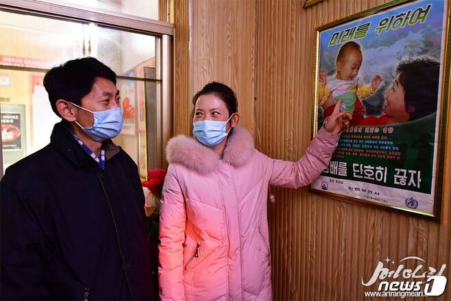 금연 포스터를 보고 있는 북한 주민들. ('메아리' 갈무리)© 뉴스1