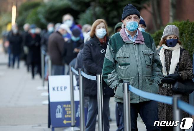 지난 22일 영국 런던 소재 로드 크리켓 구장 앞에서 시민들이 코로나19 백신을 맞기 위해 줄 지어 서 있다. © 로이터=뉴스1
