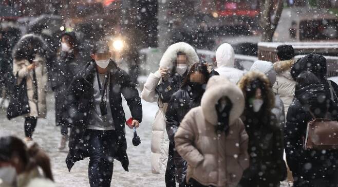눈이 내린 12일 저녁 서울 강남역 인근에서 시민들이 퇴근길을 재촉하고 있다. 기상청은 28일 강한 추위와 함께 전국 대부분에 눈 또는 비가 올 것이라 예보했다. 연합뉴스 제공
