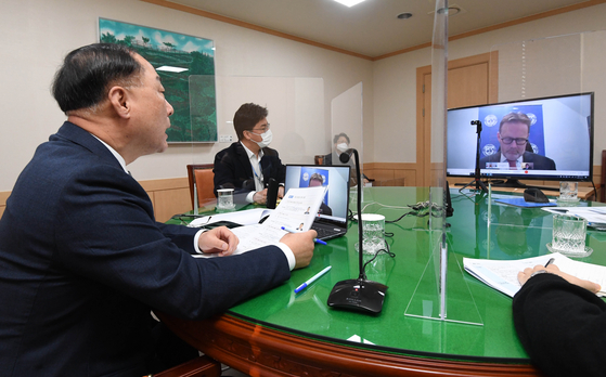 Korean Finance Minister Hong Nam-ki. left, talks with Andreas Bauer, an International Monetary Fund official in charge of Korea, in a teleconference on Thursday. [YONHAP]