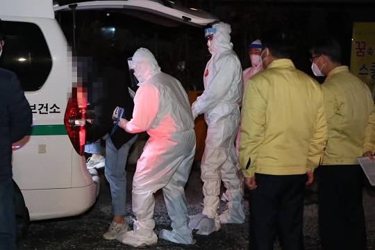 광주 광산구 운남동 광주TCS국제학교에서 방역당국 관계자가 코로나19 음성 판정을 받은 합숙생을 격리 시설로 이송하고 있다. 연합뉴스