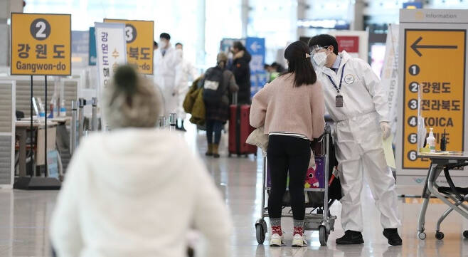 국내에서 영국발 코로나19 변이 바이러스 감염자가 추가로 확인되고 있는 가운데 인천국제공항 1터미널 입국장에서 방역 관계자들이 해외입국자들에게 식별 스티커를 부착해주고 있다.[연합]