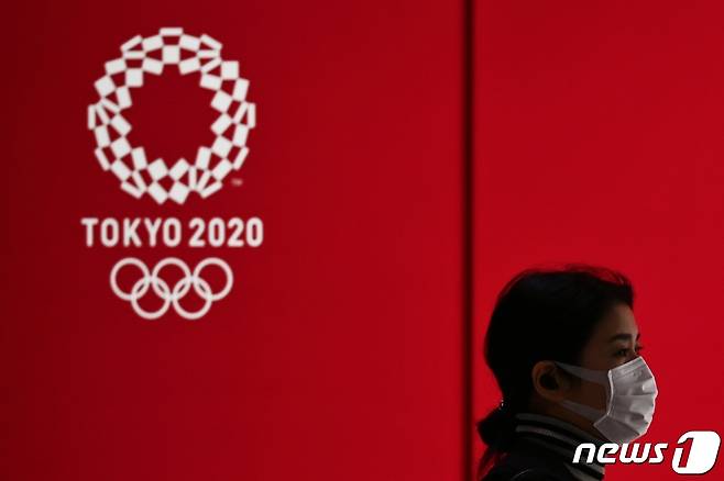 일본 도쿄올림픽 로고 앞으로 마스크를 착용한 시민이 지나가는 모습. <자료사진> © AFP=뉴스1