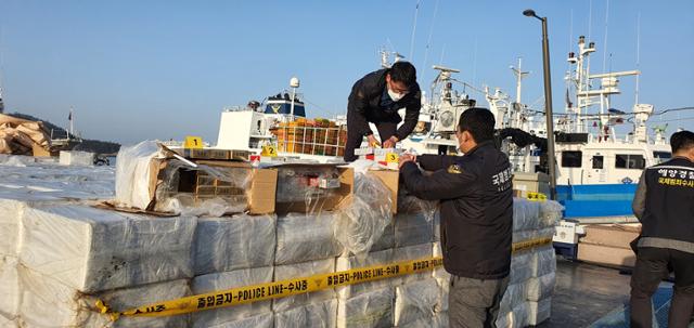28일 오전 목포해양경찰 전용부두에 정박중인 밀수 어선에서 해경이 밀수품을 확인하고 있다. 목포해양경찰서 제공