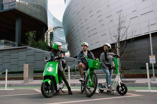 Models pose with (left to right) an electric moped, an electric bicycle and an electric scooter from Lime. (Lime)