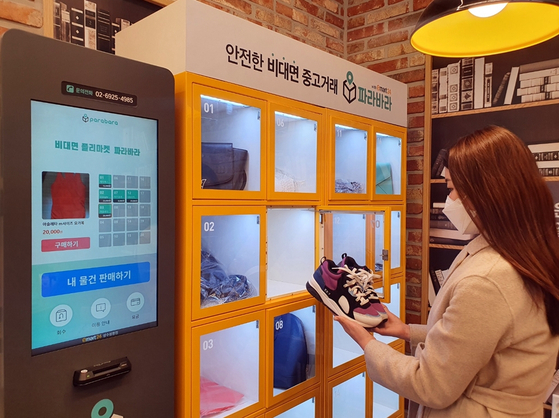 A customer looks at secondhand shoes at a secondhand exchange machine at an Emart24 store in Seoul. The convenience store is testing secondhand exchange machines developed by Parabara. The machines are located in 18 Emart24 stores across the country. With many people affected economically by Covid-19, secondhand exchanges are growing in popularity.