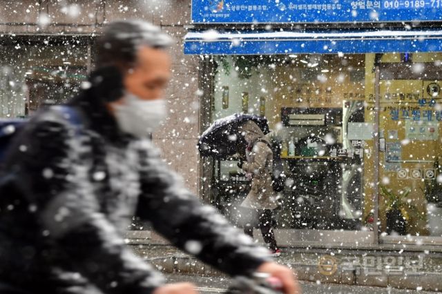 28일 눈이 오는 마포구의 한 도로에서 행인이 우산을 쓴 채 걷고 있다.