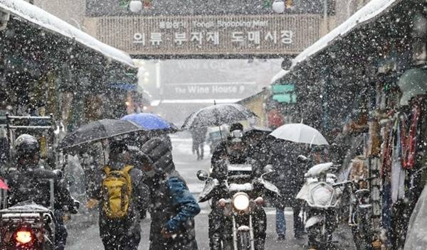 서울·경기북부 지역에 대설주의보가 내려진 28일 오전 서울 중구 동대문 평화시장에서 시민들이 상점 앞을 지나고 있다. 연합뉴스