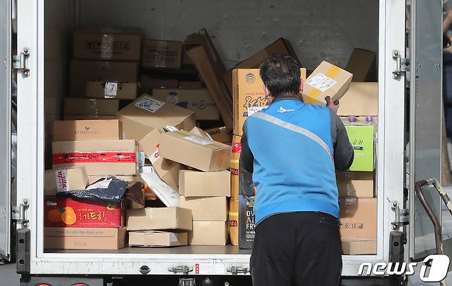 25일 서울 시내에서 한 택배기사가 택배 상자를 옮기고 있다. . 2021.1.25/뉴스1 © News1 이성철 기자