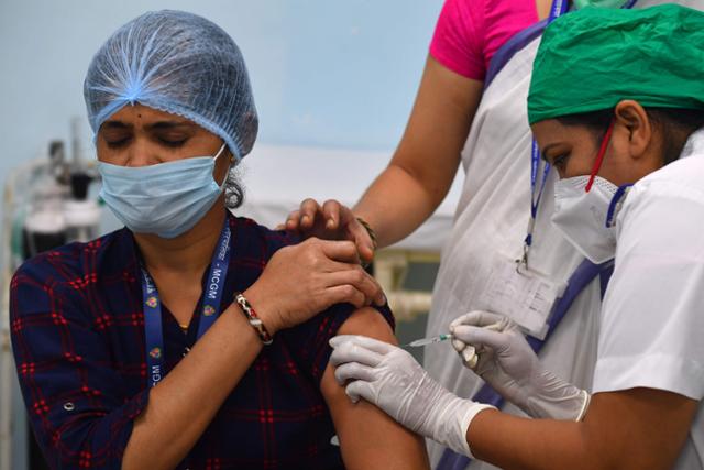 인도 뭄바이의 한 의료인이 지난 16일 백신 접종을 받고 있다. 인도는 코로나19 누적 확진자 숫자가 1,000만명을 넘어 세계 2위다. 뭄바이=AFP연합뉴스