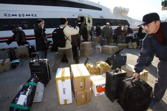 2006년 속초로 귀환한 한반도에너지개발기구(KEDO) 관련 직원들이 한국 선박인 `한겨레호`에서 짐을 내리고 있다. [중앙 포토]