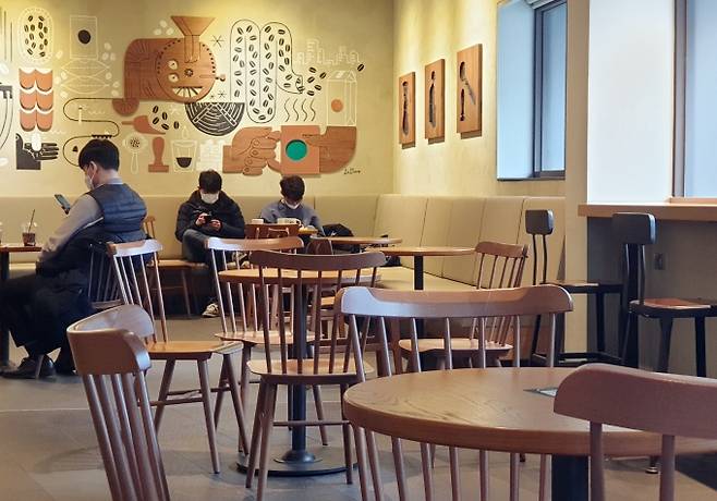 18일 서울 명동 한 카페에서 시민들이 매장 내 좌석에 앉아 음료를 마시고 있다. 이날부터 카페 등 다중이용시설의 방역 조치가 일부 완화되면서 포장·배달만 가능했던 카페에서 오후 9시까지 매장 내 취식이 허용된다. 박효상 기자