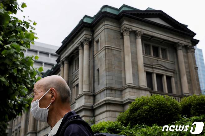 일본 수도 도쿄의 일본은행 앞을 한 시민이 마스크를 쓴 채 지나가고 있다. © 로이터=뉴스1