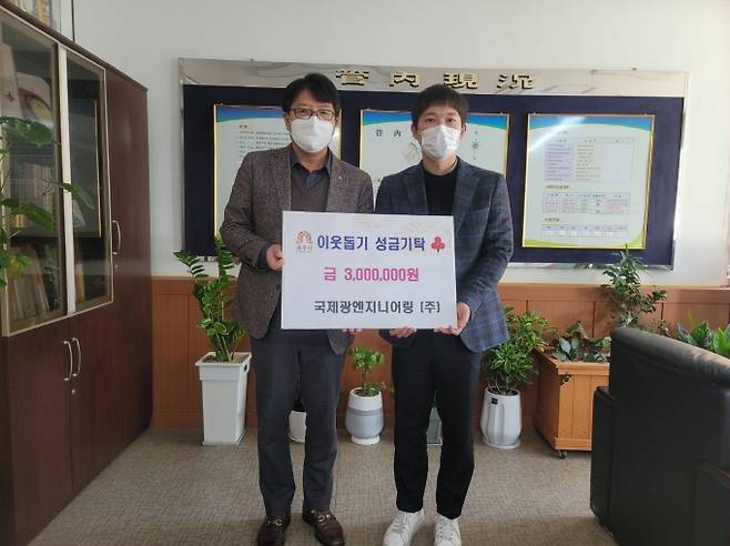 ㈜국제광엔지니어링 조영우(오른쪽)대표이사가 조호현 회장을 대신해 김재철 반포면장에 어려운 이웃돕기 성금을 기탁하고 있다.